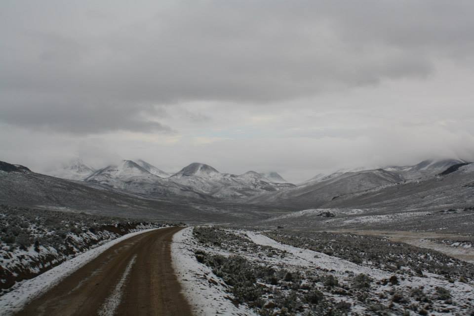 A snow-covered dirt road leading into the mountains in Peru